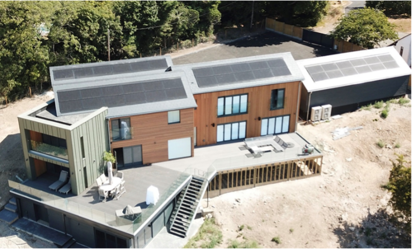 An aerial view of a house with solar panels on the roof.