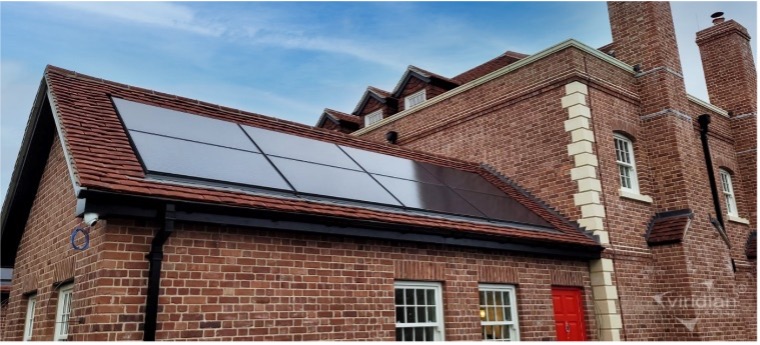 A brick building with a solar panel on the roof.