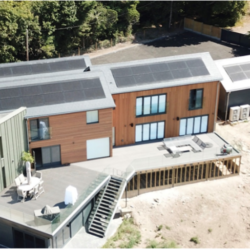 An aerial view of a house with solar panels on the roof.