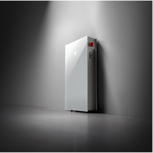 A side angle image of a Tesla Powerwall 3, spotlighted on a black background.